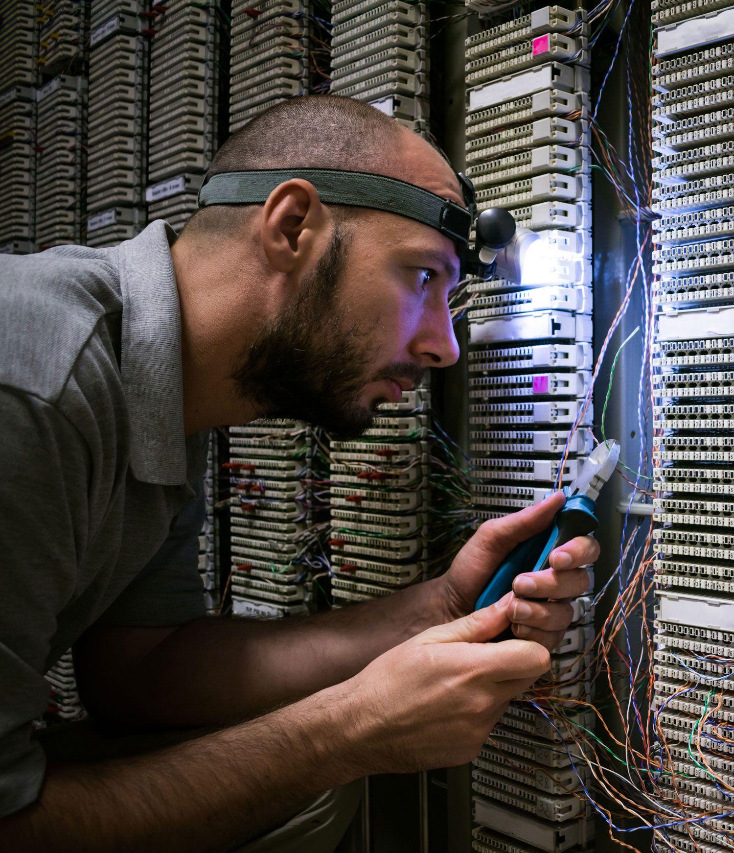 A technical expert inspecting a computer server and carrying out repairs