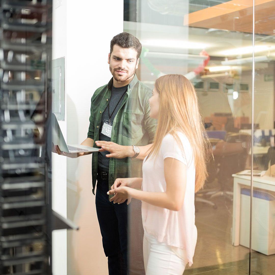 Two people talking while in a server room