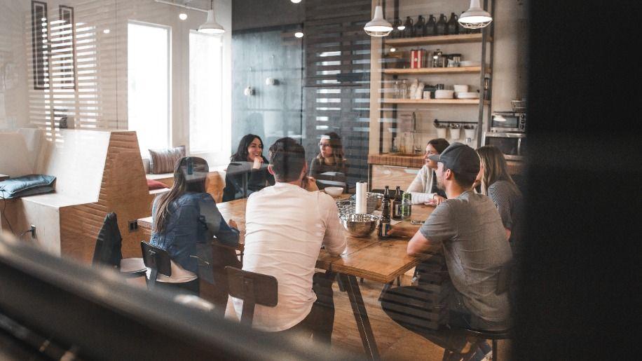 Multiple people sat around a table having a business meeting