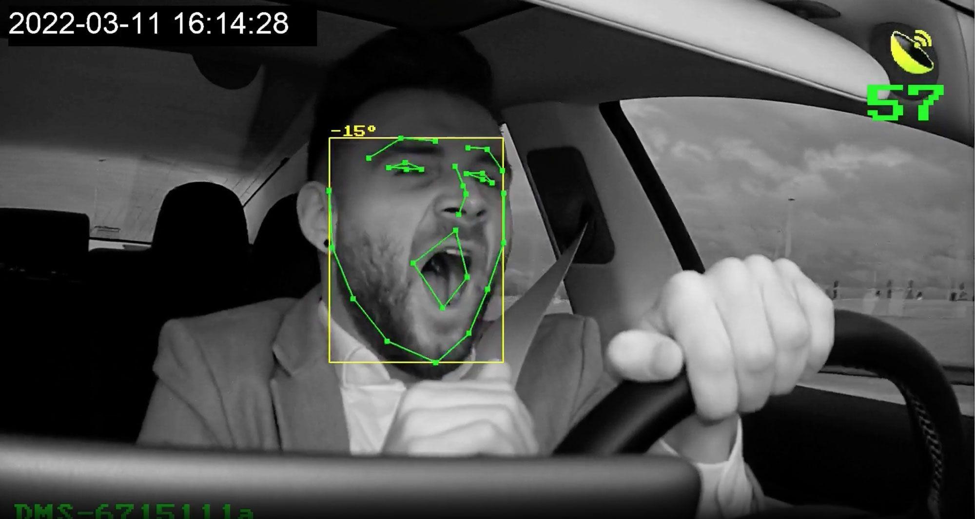 A driver yawning while driving their vehicle